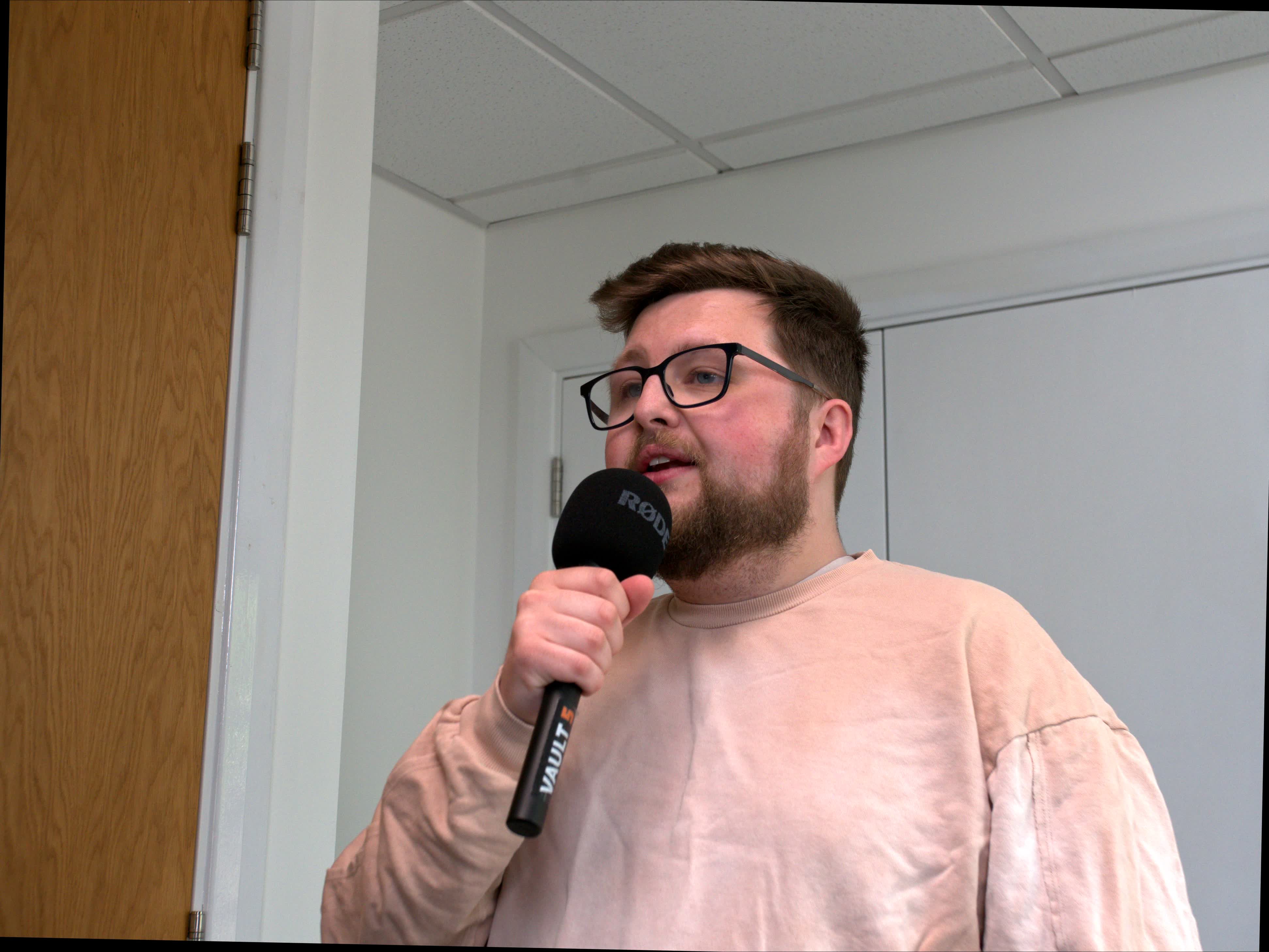 Josh speaking into a microphone recording charity content