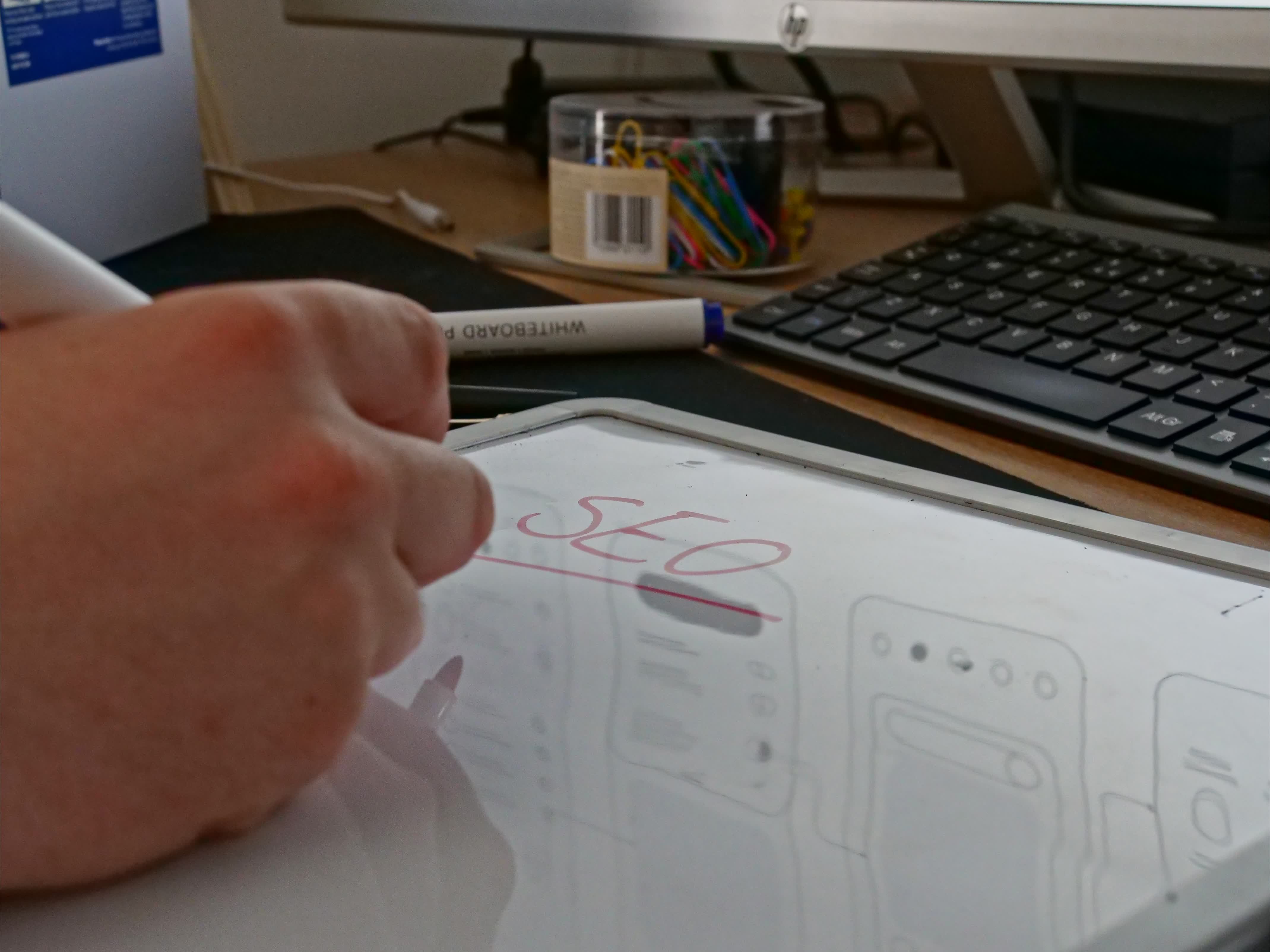 Josh writing SEO strategy on a whiteboard for a charity client
